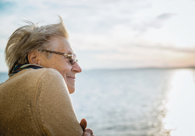 Mand smiler og ser ud over havet